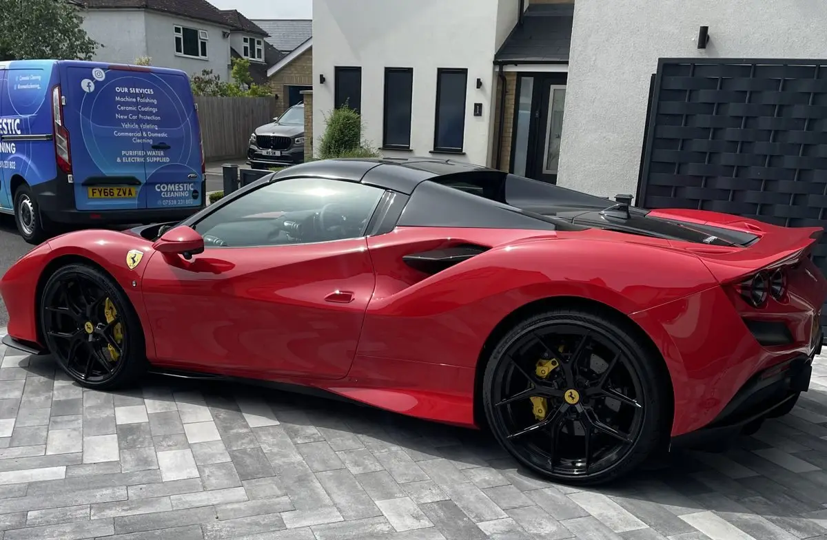 A red Ferrari detailed on location, with the branded Comestic Cleaning van beside it, Essex