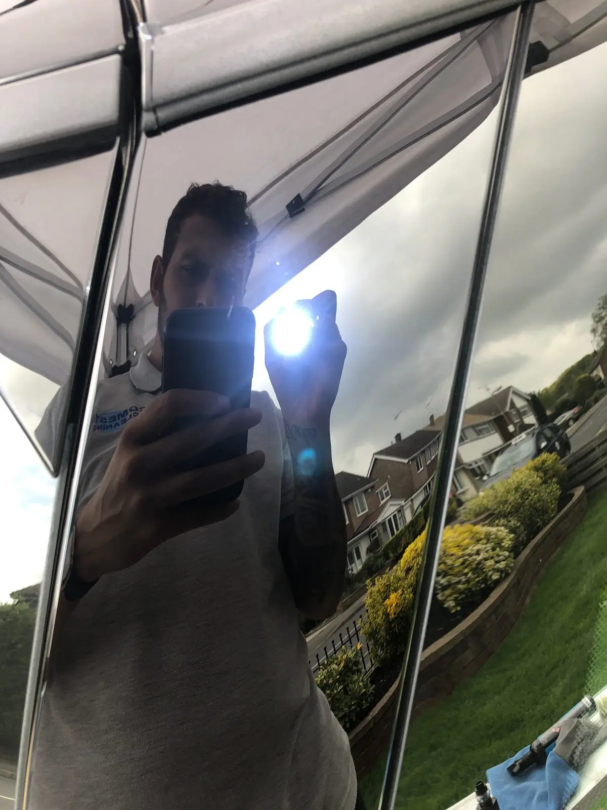 A car panel detailed to a flawless mirror gloss, Joe reflected in the paintwork, Essex