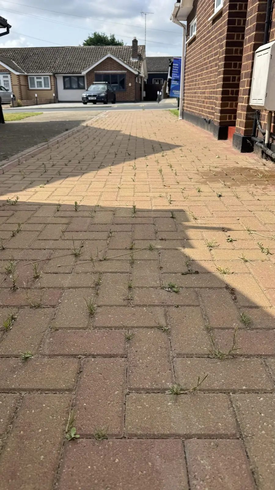Red and tan block paving driveway before cleaning, dirty and weathered
