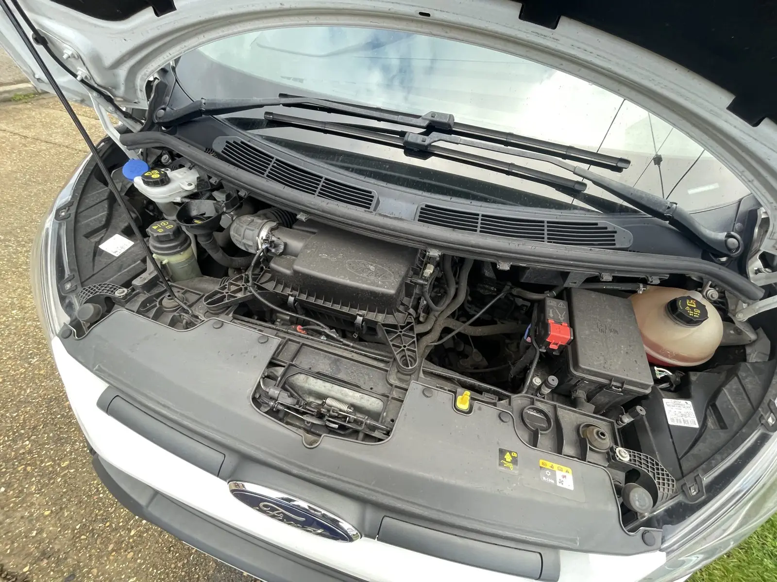 Engine bay before detailing, covered in grease, oil and road grime