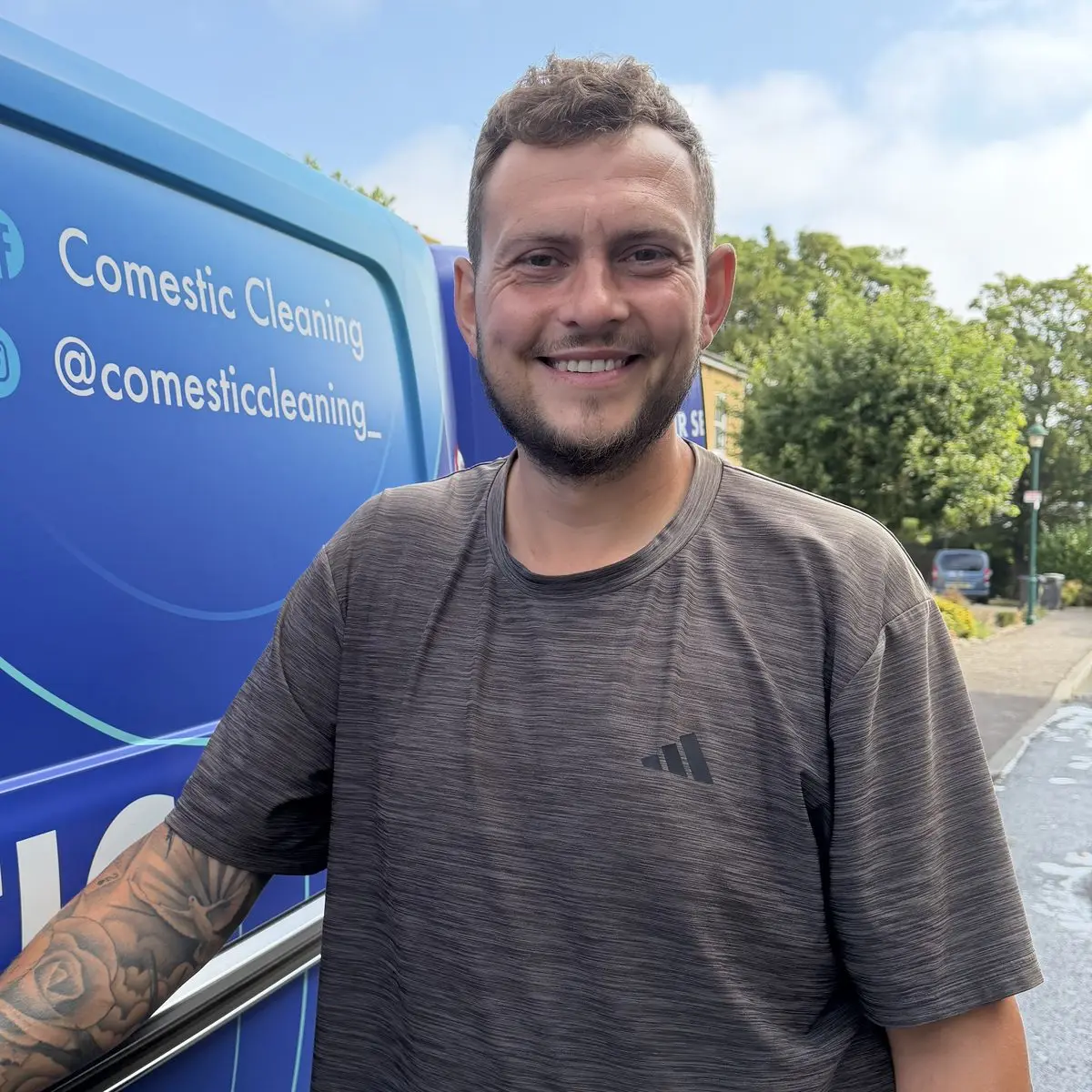 Joe, the owner of Comestic Cleaning, smiling beside his branded van in Essex