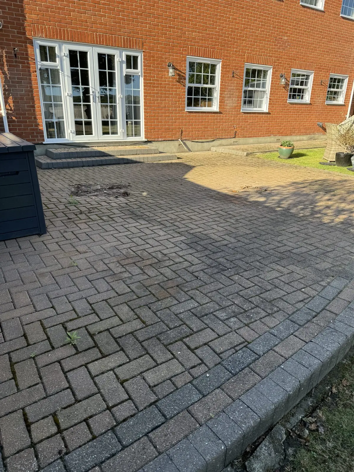 Block paving patio before cleaning, dulled by dirt and algae