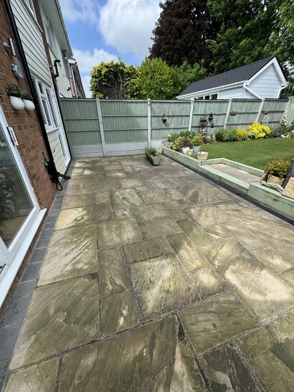 Indian sandstone patio before cleaning, darkened with algae and dirt