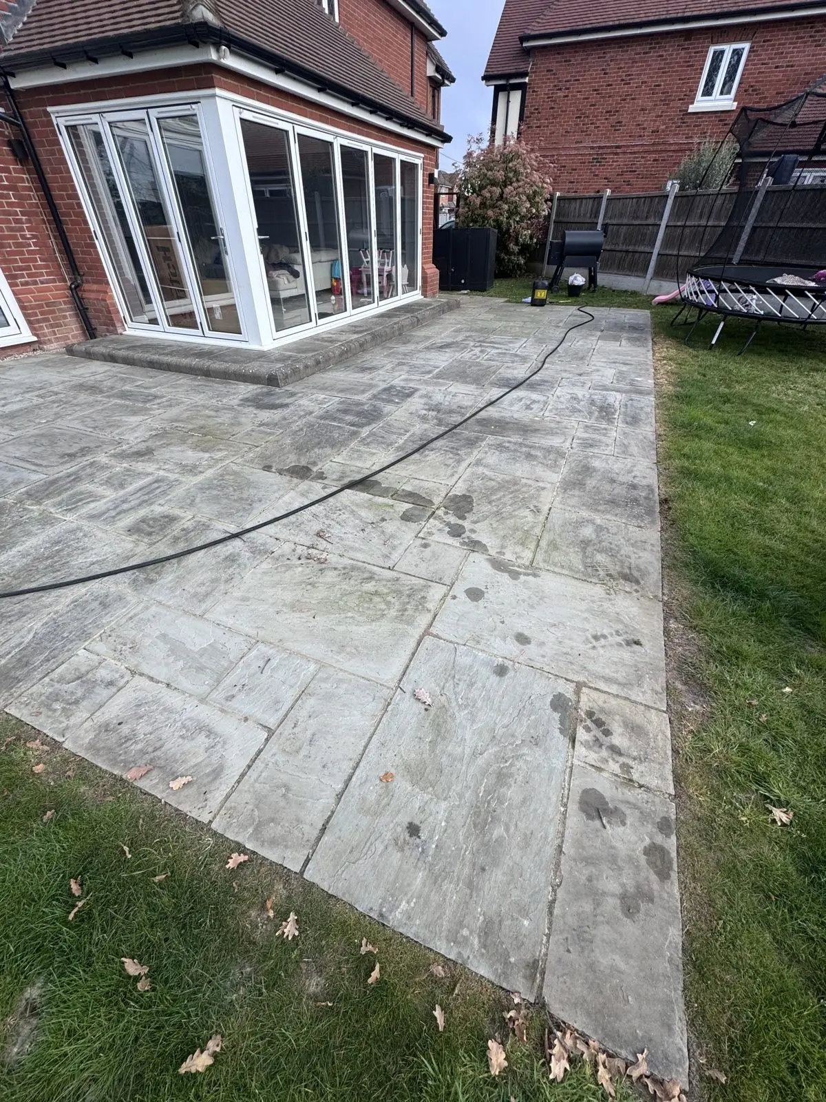 Sandstone patio before cleaning, stained and weathered