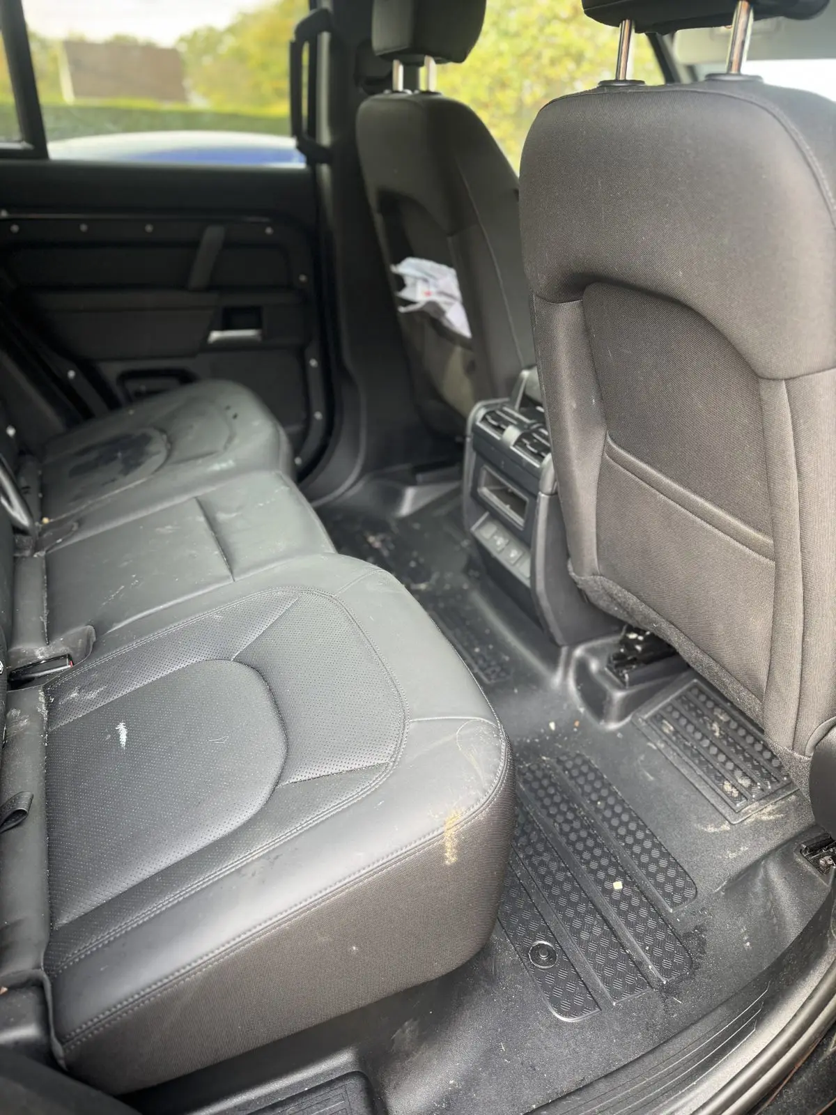 Land Rover Defender rear cabin before cleaning, crumbs and debris across the seats and floor