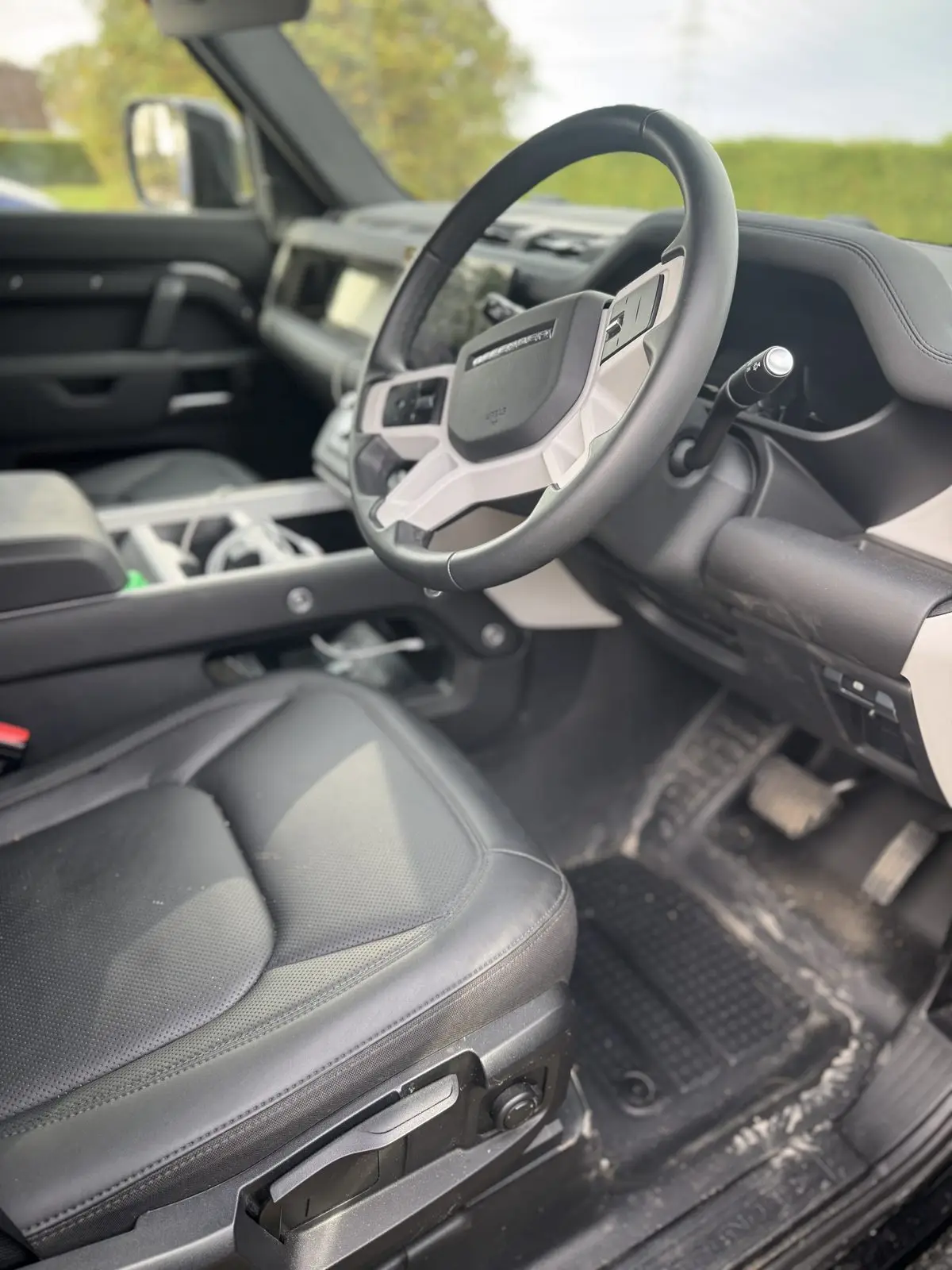 Land Rover Defender cabin before cleaning, footwell dirty and the mat missing