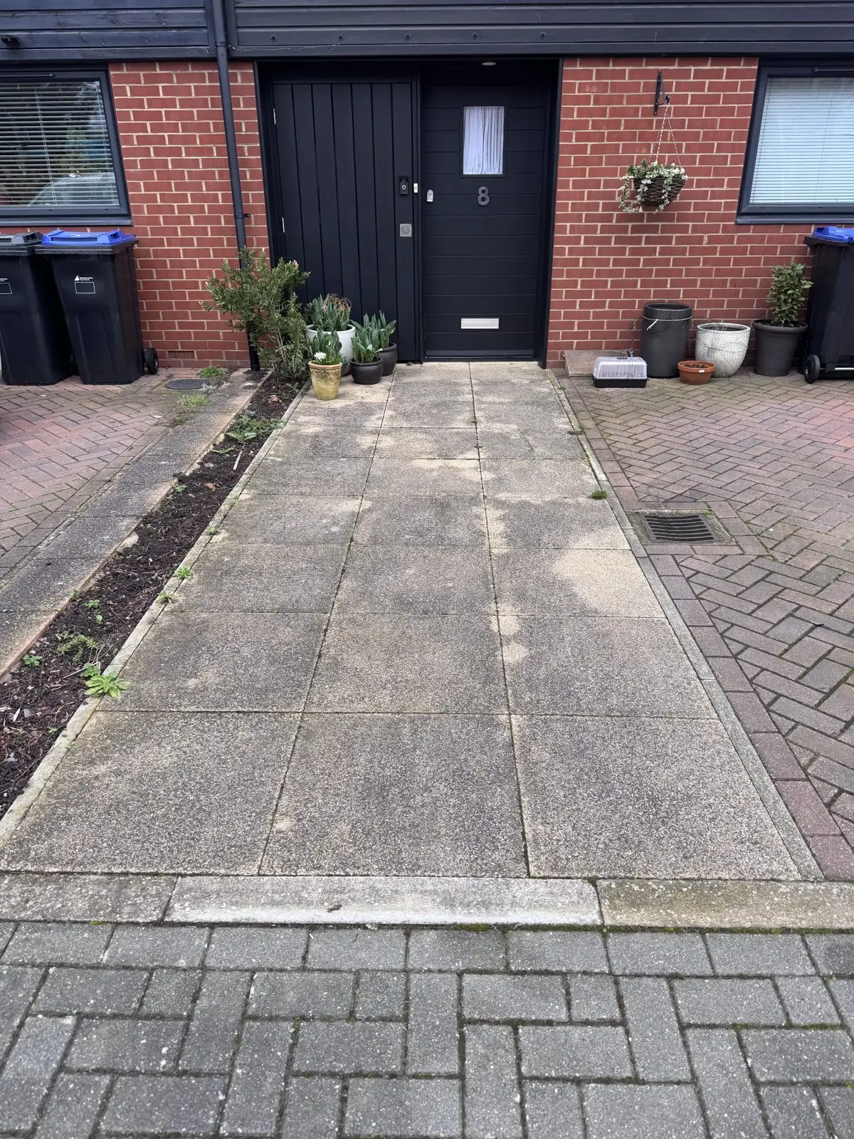 Paving slabs before cleaning, dull grey and weathered