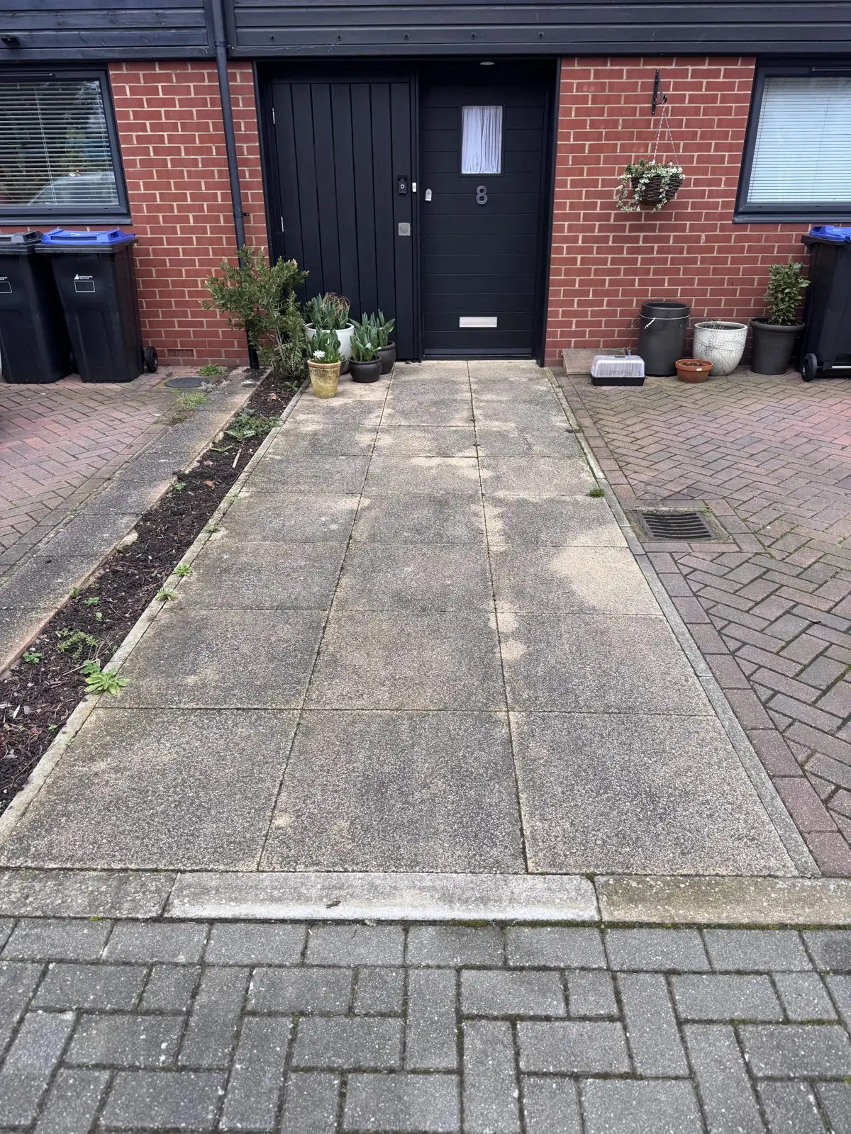 Paving slabs before cleaning, dull grey and weathered